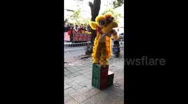 Girl enthusiastically practices lion dance as passing troupe plays music for her