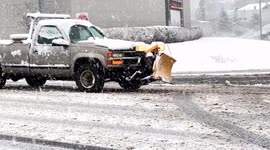 Snowstorm in February 2024 on East Coast. Small plowing truck moving from Post Road to I 95 South at Exit 14  during heavy snowing and slippery road. Winter blizzard in February 2024