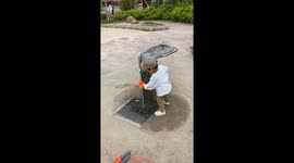 This little boy can't quite figure out how to use this water fountain
