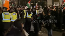 Police form a cordon and move to push protesters off the road