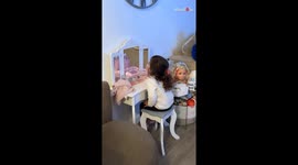 Mirror mischief: Little sister covertly glances at TV through the makeup table's mirror
