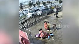 Falling snow narrowly misses mother sitting outside with her baby in her arms