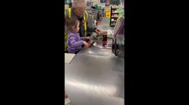 Toddler helps cashier at UK supermarket making for wholesome moment