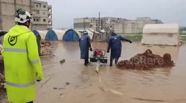 Rescuers clear displaced people's camps from rainwater in Suraan, Syria