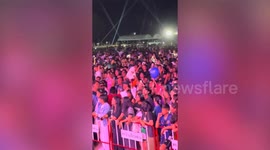 Concert goer holds aloft his pet cat at rock show