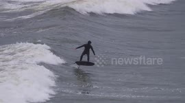 UK Weather. Hydroblade surfers ride the waves at Porth Beach between gales. Porth Beach, Newquay, Cornwall, UK