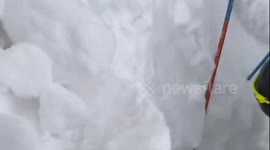 Emergency services frantically dig away snow after avalanche kills 1 and traps 6