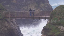 UK Weather, Winter Storm watching on a bridge over a furious sea, Porth Island, Newquay, Cornwall, UK