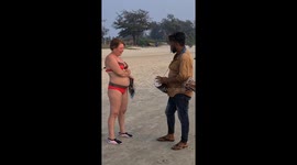 Indian beach hawker speaks fluent Russian tries to sell drums to Russian lady on Cavelossim beach in Indian state of Goa