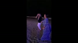 Foreign tourists from Kazakhstan with playboy logo dance on Benaulim beach in the Indian state of Goa