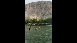 Tourists swim unfazed as landslide unfolds nearby