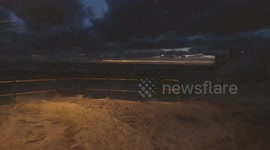 Waves whipped up by strong winds crash over seawall and onto camera in St Ives