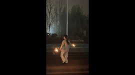 Dancer holds sparklers and spins rapidly with arms outstretched in mesmerising display