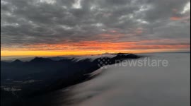 Sunlight penetrates the clouds, illuminating the distant mountains in Shanwei, China