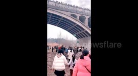 Chinese villagers scatter cash by bridge for blessings on Lantern Festival