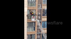 Firefighters brave ladder to rescue mother and daughter trapped in burning flat in China