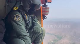 Firefighters fly over forest to dump extinguishers over raging wildfire in Thailand