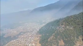 Firefighters use helicopter bucket to douse forest fire