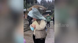 Wild macaque rummages through woman's rucksack before running away with box of juice