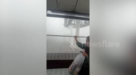Holidaymakers take foggy tour along cable car while raining