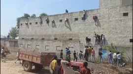 Family and friends scale walls to pass cheats to students taking exam in north India