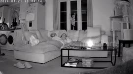 Couple Watching TV Startled When Ghost Blows Out Candle On The Coffee Tableandle