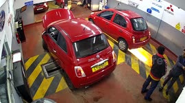 Moment woman disappears into vehicle inspection pit - while looking at her car following MOT