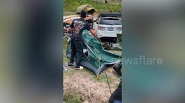 Camper struggles to pitch tent on hill amid windy weather