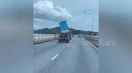 Wonky lorry sits on back of pickup truck on way to repair shop