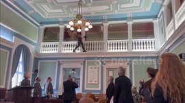 Immigration protester dangles from balcony above MPs