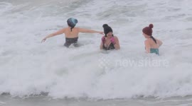 International Womens Day. Five women celebrate on Fistral Beach, Newquay, Cornwall, UK