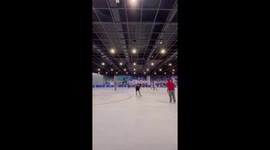 Ice skater falls on the ground while spraying