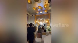 Bride's flower falls into groomsman's lap at bouquet toss ceremony