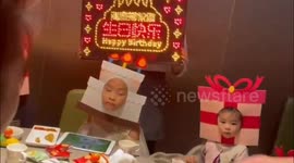 Amusing moment as Chinese kids wear cake and gift headgear to celebrate birthday