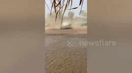 Gust blows over tents on banks of Mekong River
