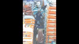 Terrifying footage shows woman get trapped under piles of grain sacks