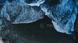 Top down aerial drone view of ocean dark waves at Bali seashore. Magnificent sea coast background