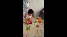 Baby girl throws shapes with her toy duck