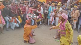 Women wielding sticks bash men hiding under shields during festival in north India