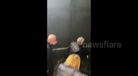 Passengers walk on tracks after power outage stalls train service in Paris