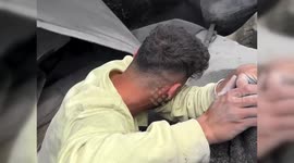 Man distraught as rescuers struggle to save his family from rubble following Israeli strike on Gaza