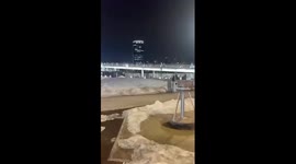 Hundreds of people run across the bridge from the Crocus building after a terrorist attack in Moscow