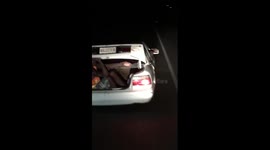 Man travels in open car boot
