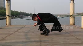 Martial artist squeezes whole body through tennis racket