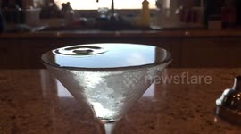 Slow-motion footage of a drop of Vermouth rippling through a Martini cocktail