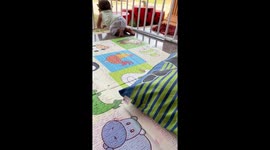 Baby pushes away playpen to make an escape