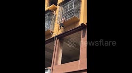 Child saved from perilous dangle on third-floor window grille
