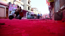 Black road looks red after century-old traditional Holi festival in India
