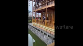 Cyclist miraculously wheeling through pond in Guizhou, China