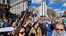 Pro-Palestine marchers carry a large puppet of a girl and names of those killed in Gaza towards Trafalgar Square